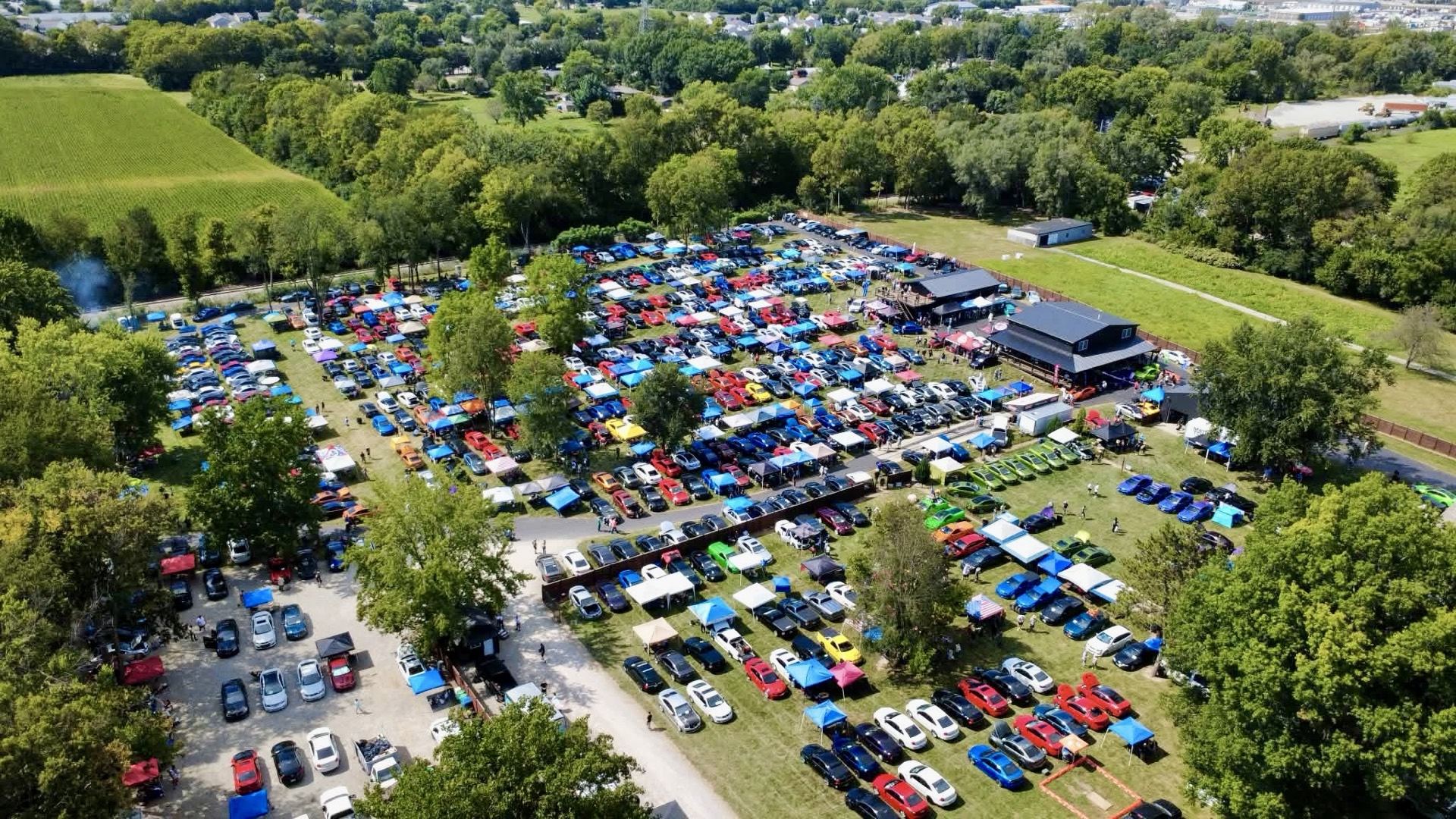 Drone shot looking down on the car show field full of Holdens and other cars