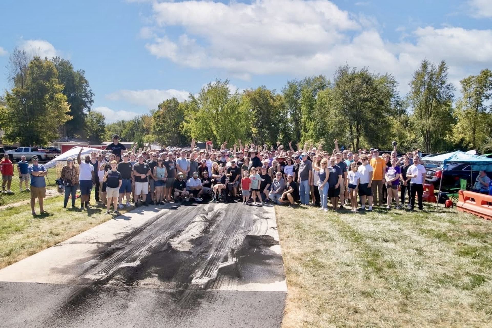 Large group of attendees standing together on the track for a group photo